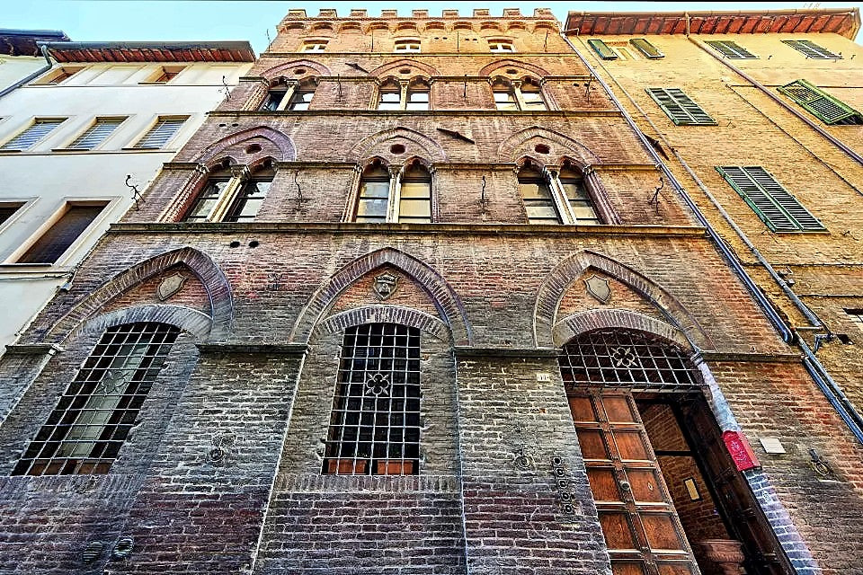 Gothic brick palazzo facade with pointed-arch windows, I Merli di Ada