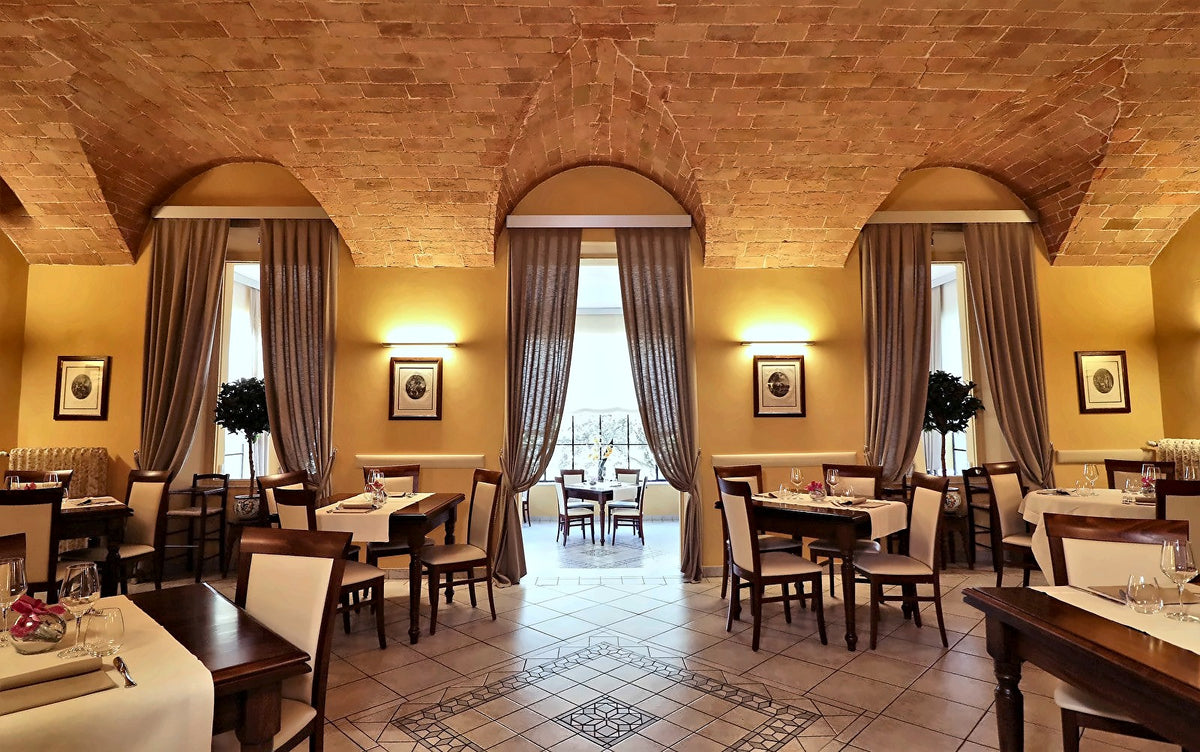 Vaulted restaurant hall with arched windows at Hotel Chiusarelli
