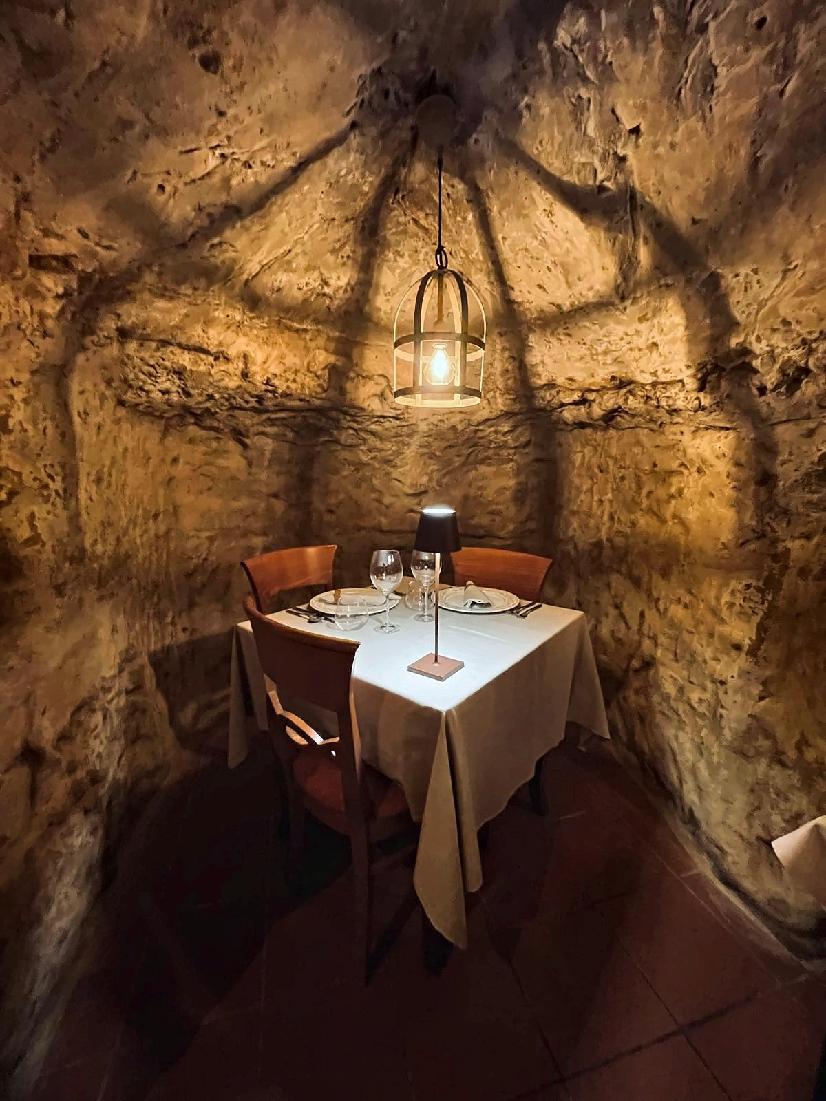 Table for two in a tufa-cut cave room at Antica Osteria Da Divo