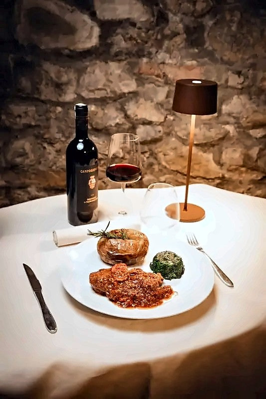 Pasta with meat sauce and red wine on a candlelit table at Antica Trattoria Botteganova