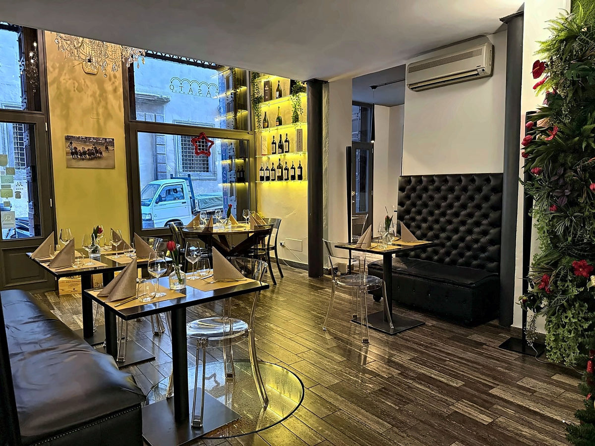 Dining room with a green wall and wine display at Casato Ristorante Wine Bar