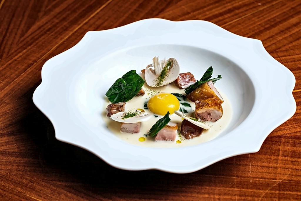 Seasonal dish with egg yolk and greens at Gallo Nero