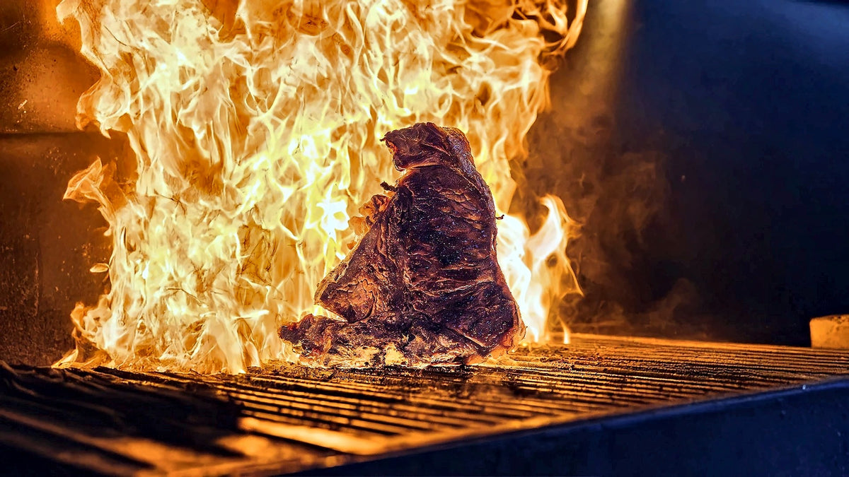 Steak searing over open flames at Premiata Braceria Toscana