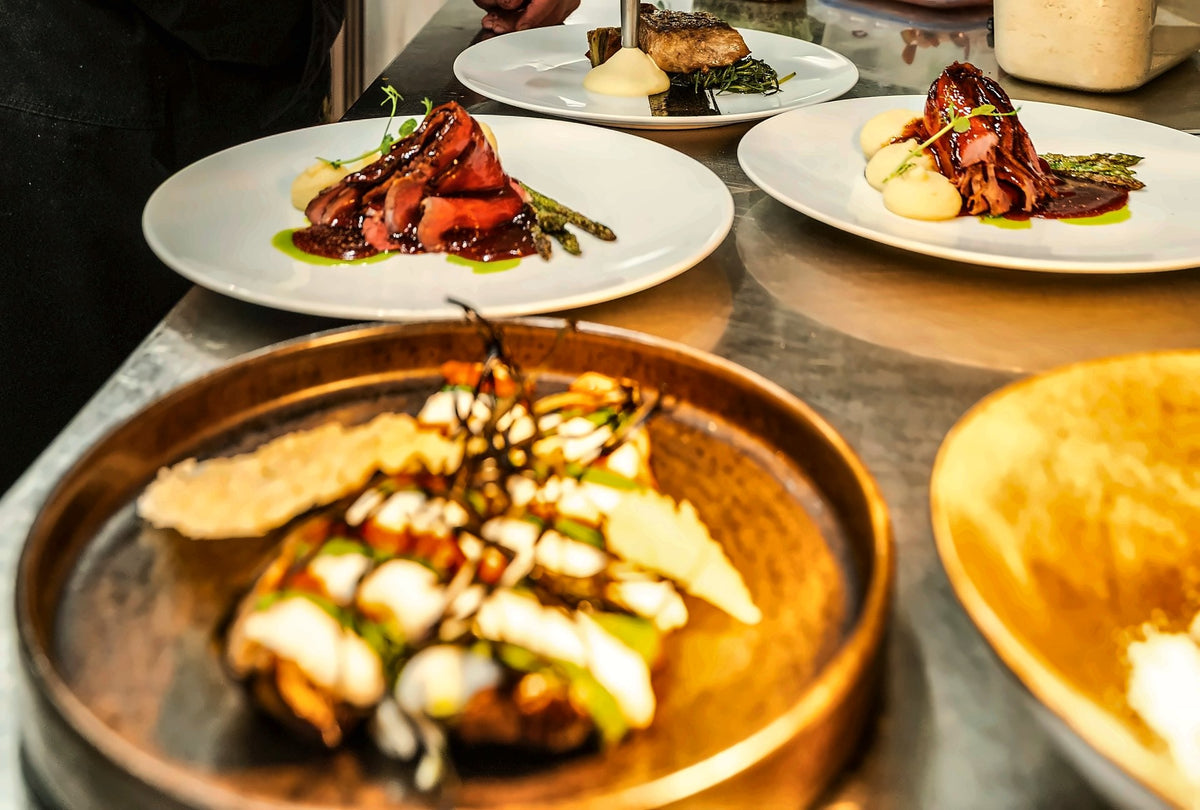 Plates ready at the pass in the kitchen of Osteria Il Cappello
