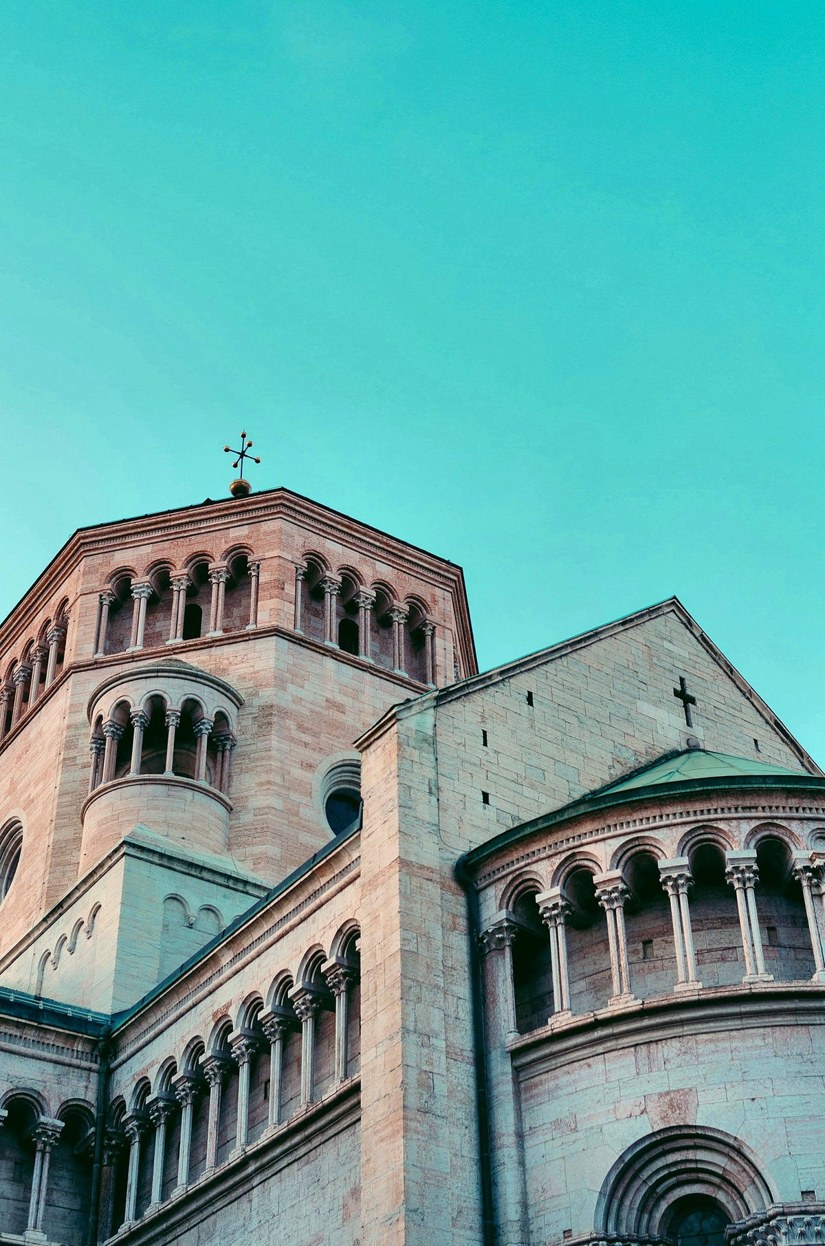 The cathedral apse in pink Trentino stone against a clear sky