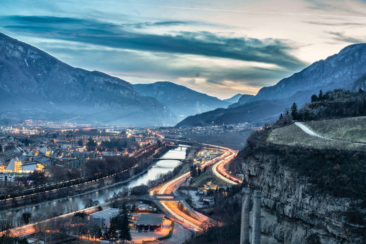 Evening panorama from Doss Trento, the Adige and the light trails of the valley