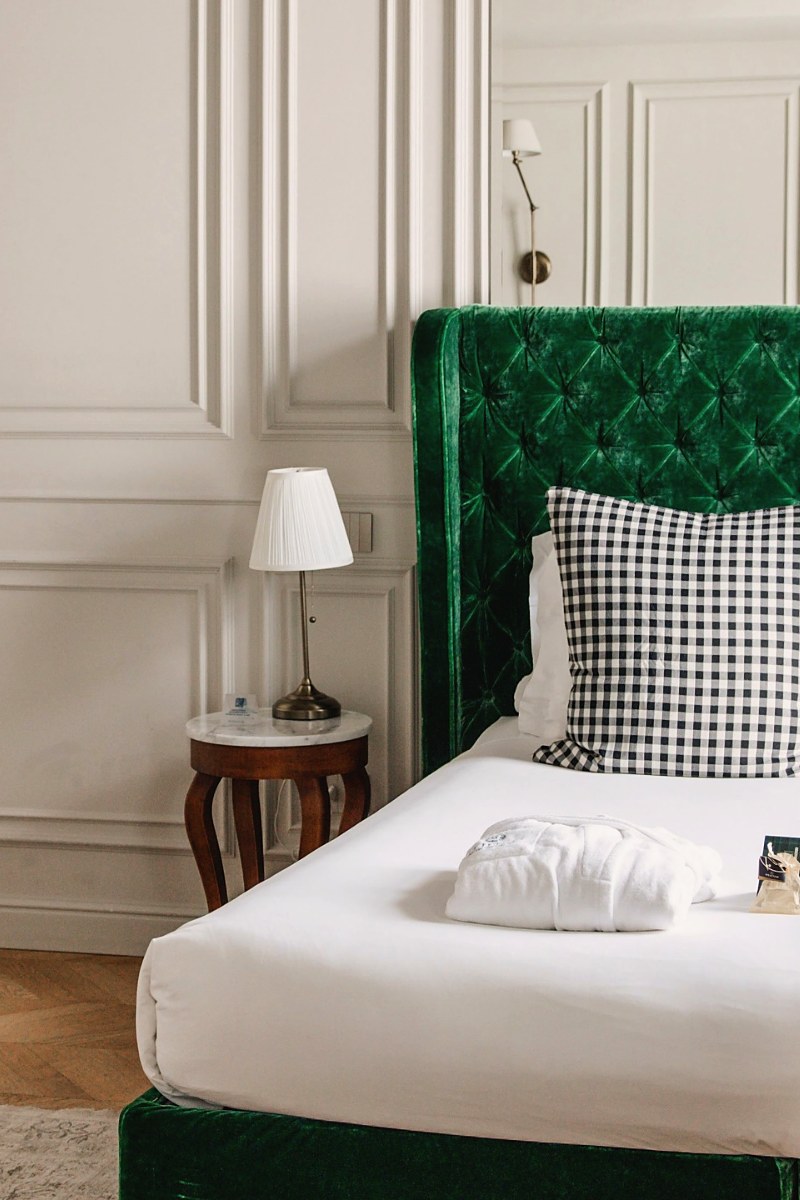 A guest room with a green upholstered headboard at Matilde Boutique Hotel
