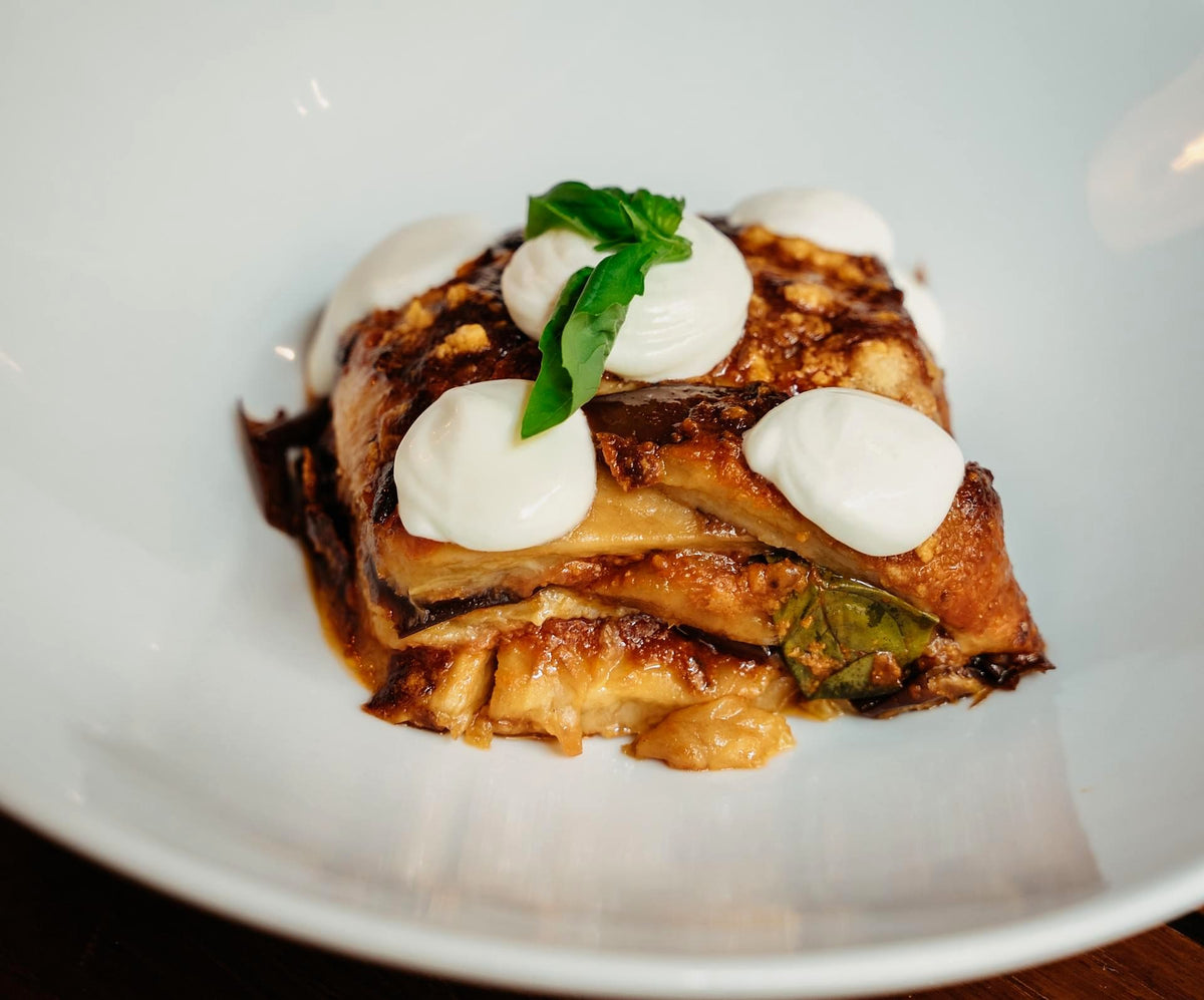 Lasagne topped with fresh cheese and basil at Osteria Brunello