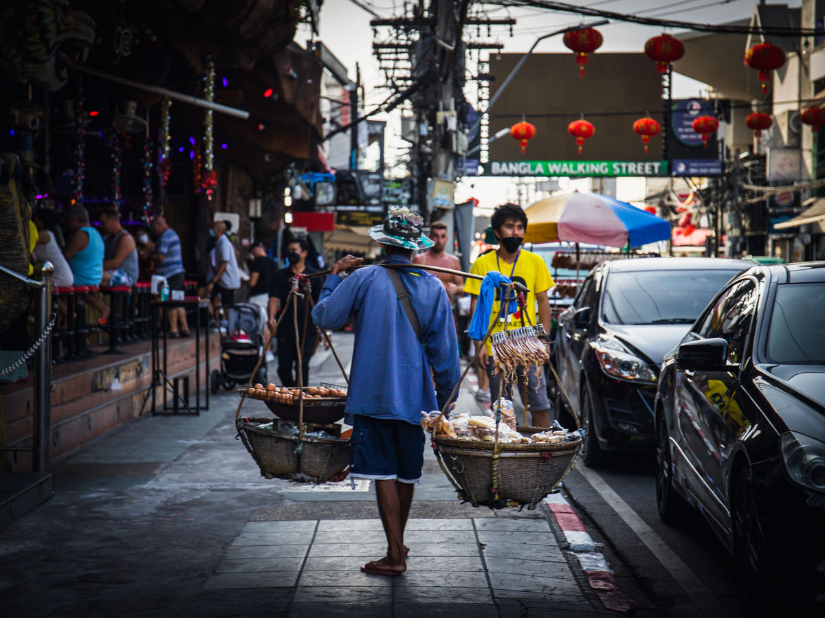 Street vendor carrying baskets on Bangla Road, Patong