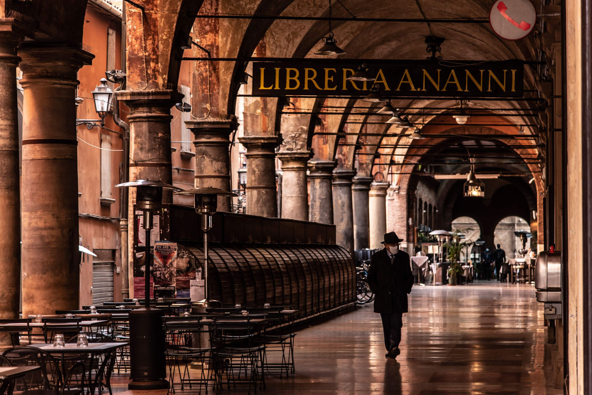 A man walking under the arches of the Portico della Morte