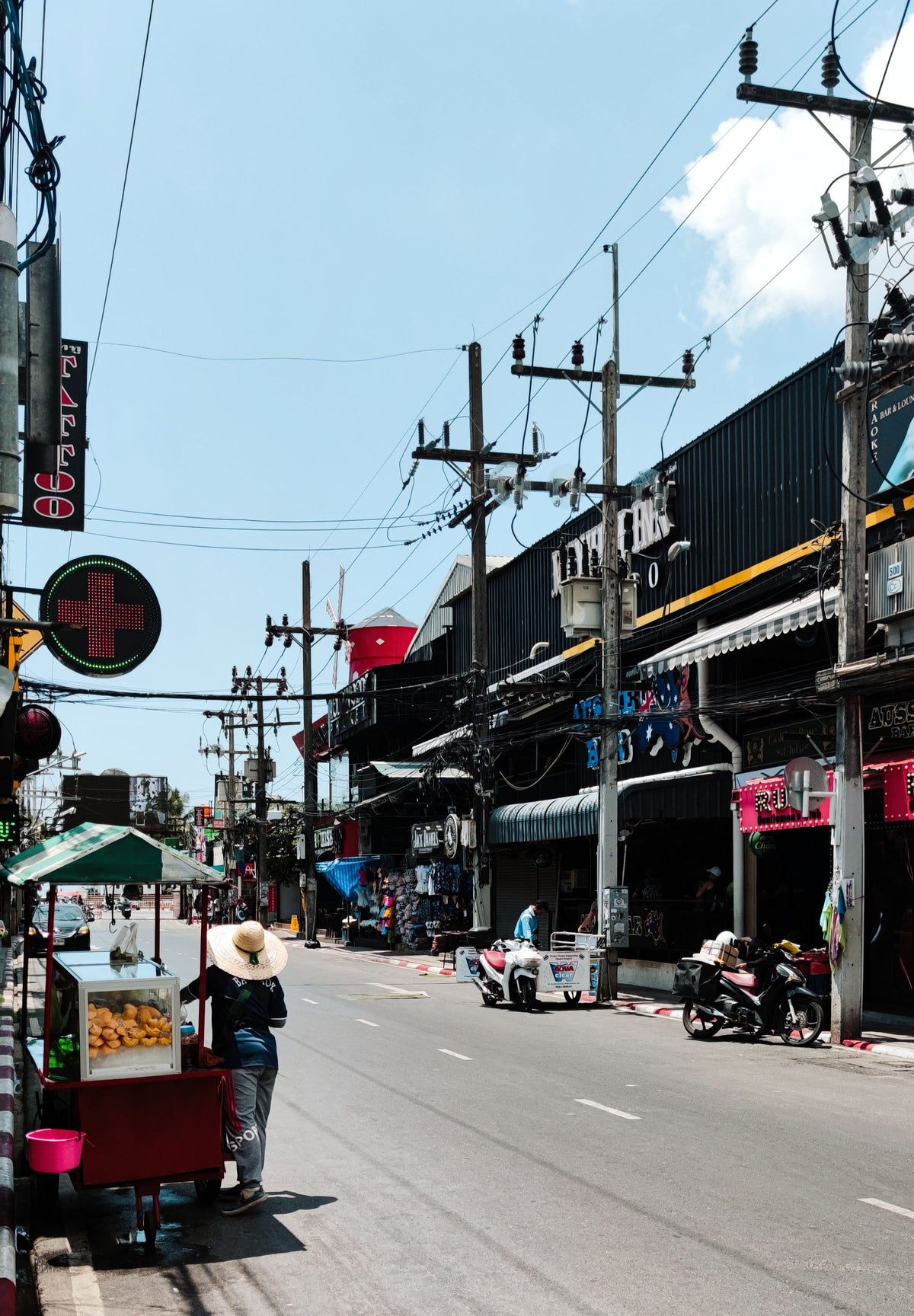 Street food cart on a sunlit street in Patong