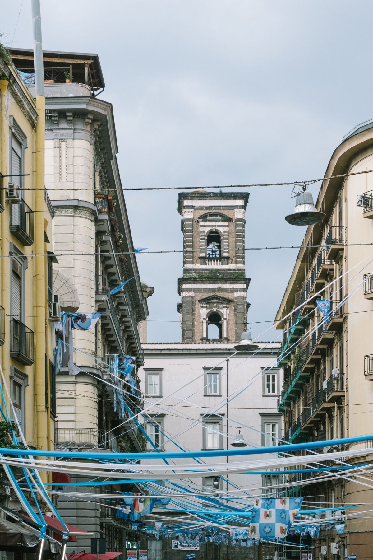 The bell tower of Sant'Agostino alla Zecca above decorated streets