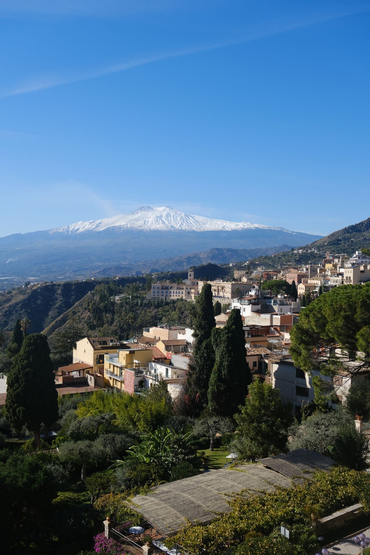 Taormina's rooftops with snowy Etna beyond