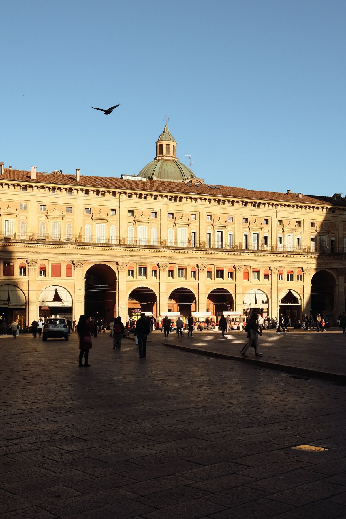 People exploring Piazza Maggiore on a sunny day