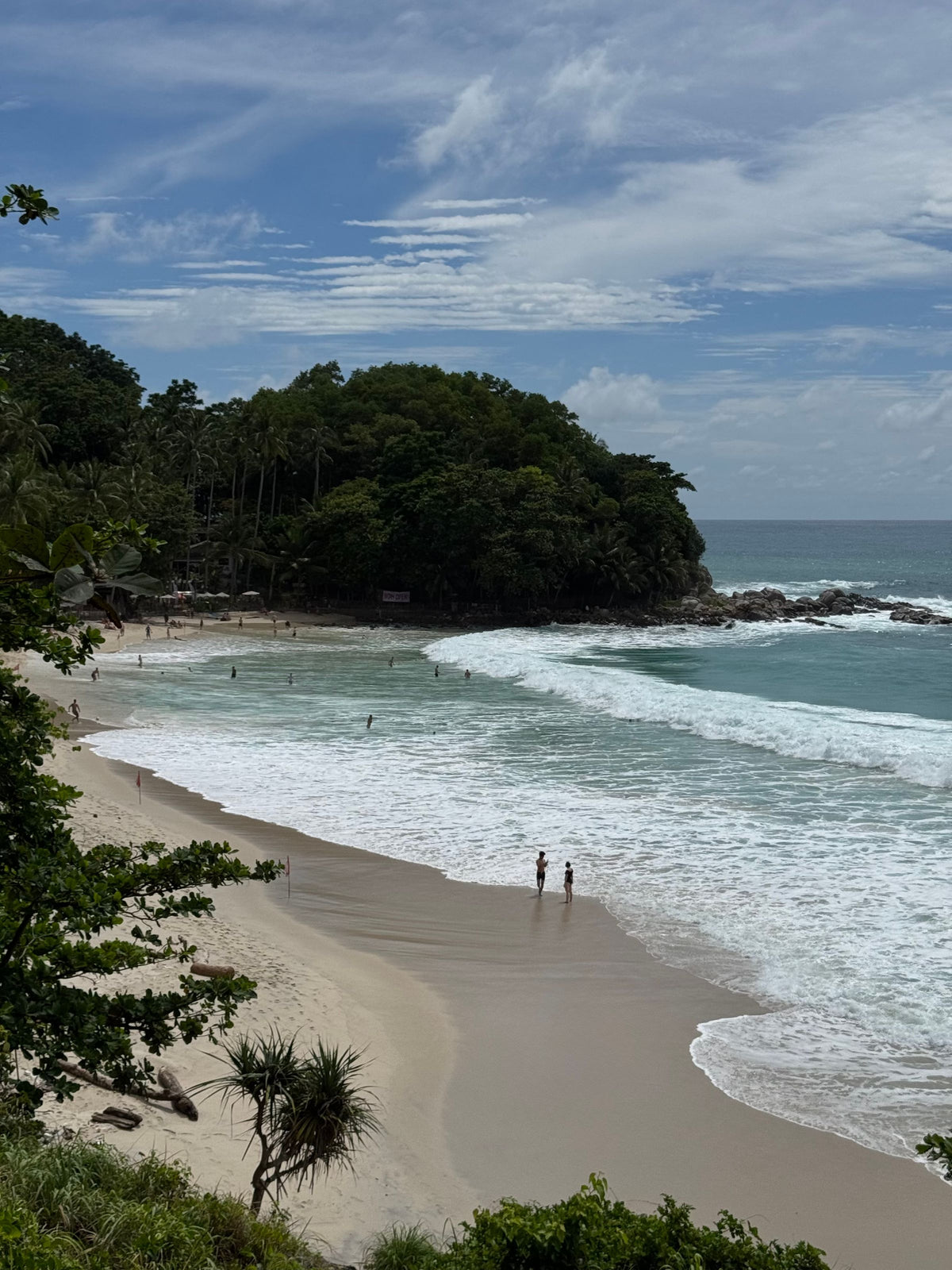 Waves on Kata Noi Beach below the wooded headland