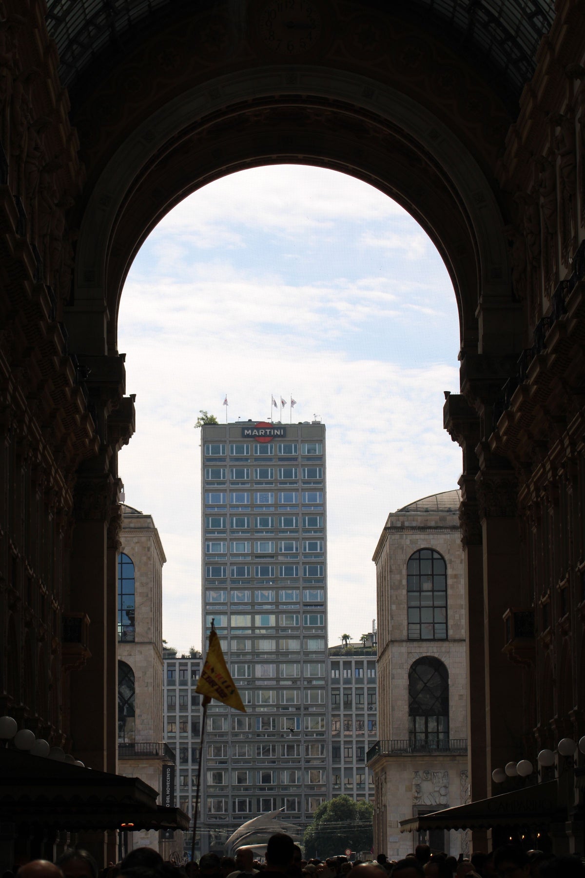 A modern tower framed by an archway of Galleria Vittorio Emanuele II