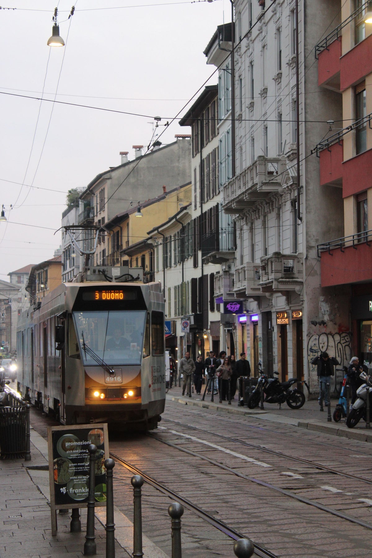 A tram on a Milan street lined with classic buildings