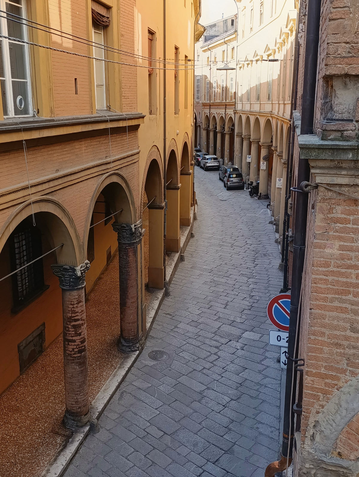A sunny porticoed street in Bologna
