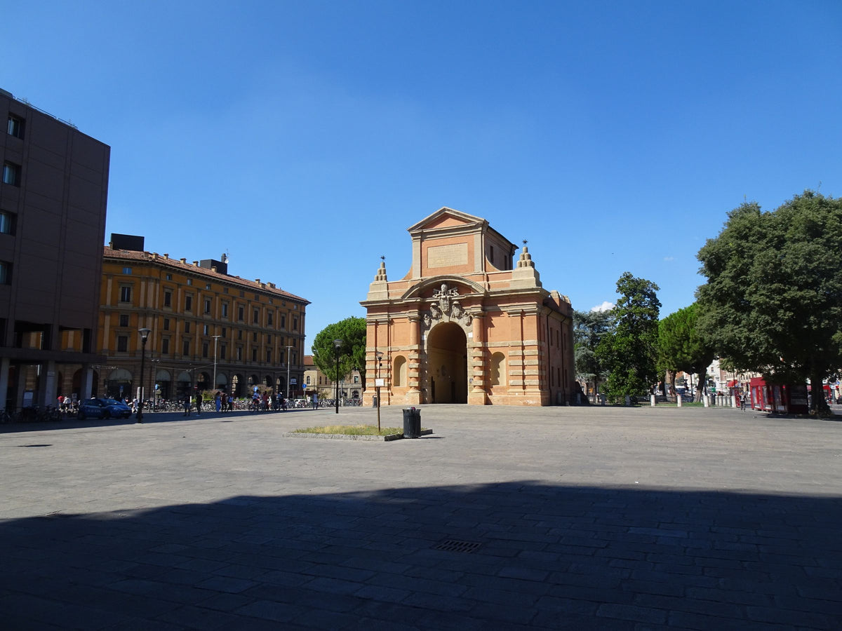 One of Bologna's historic city gates under a bright summer sky