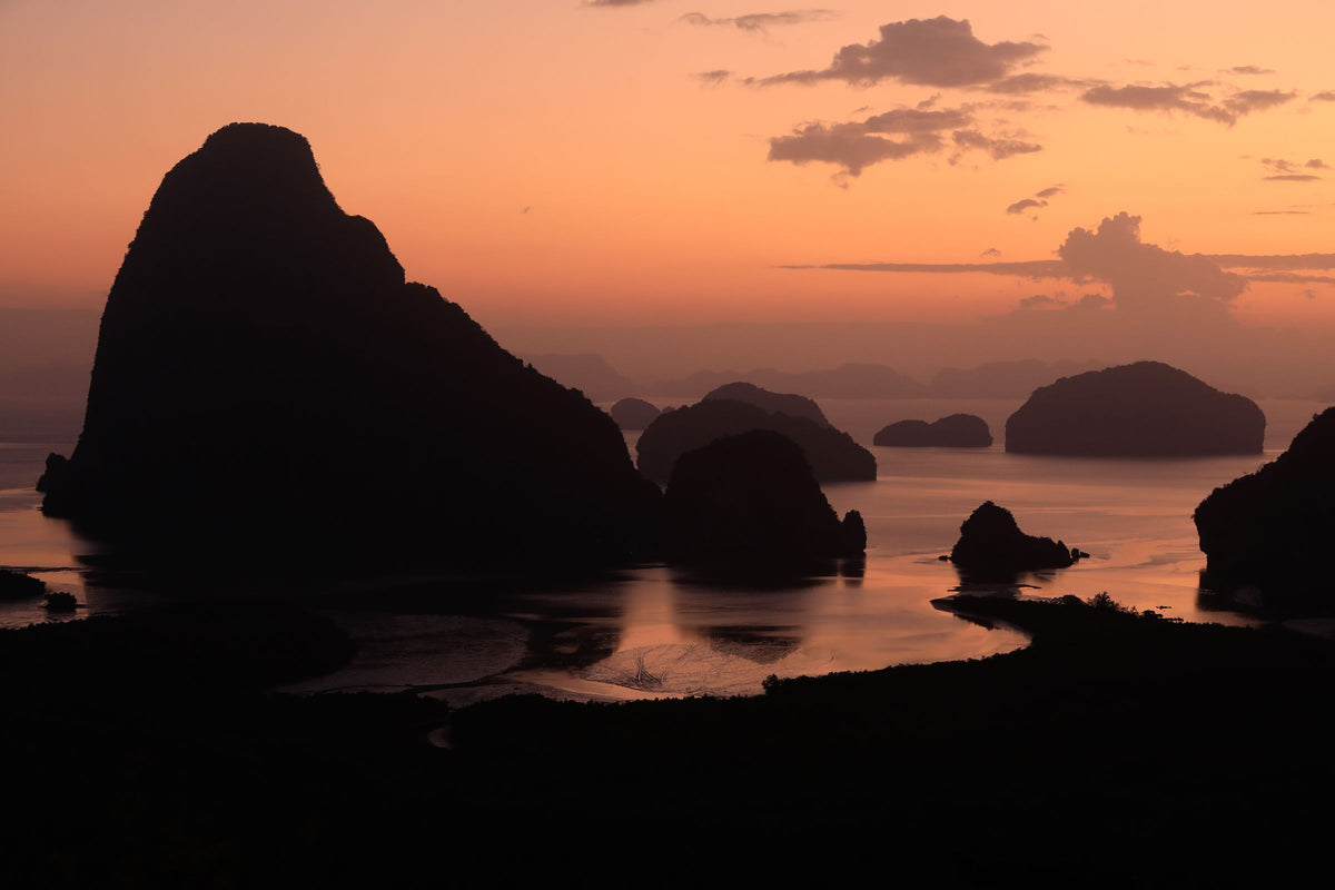 Limestone islands silhouetted at sunset in Phang Nga Bay