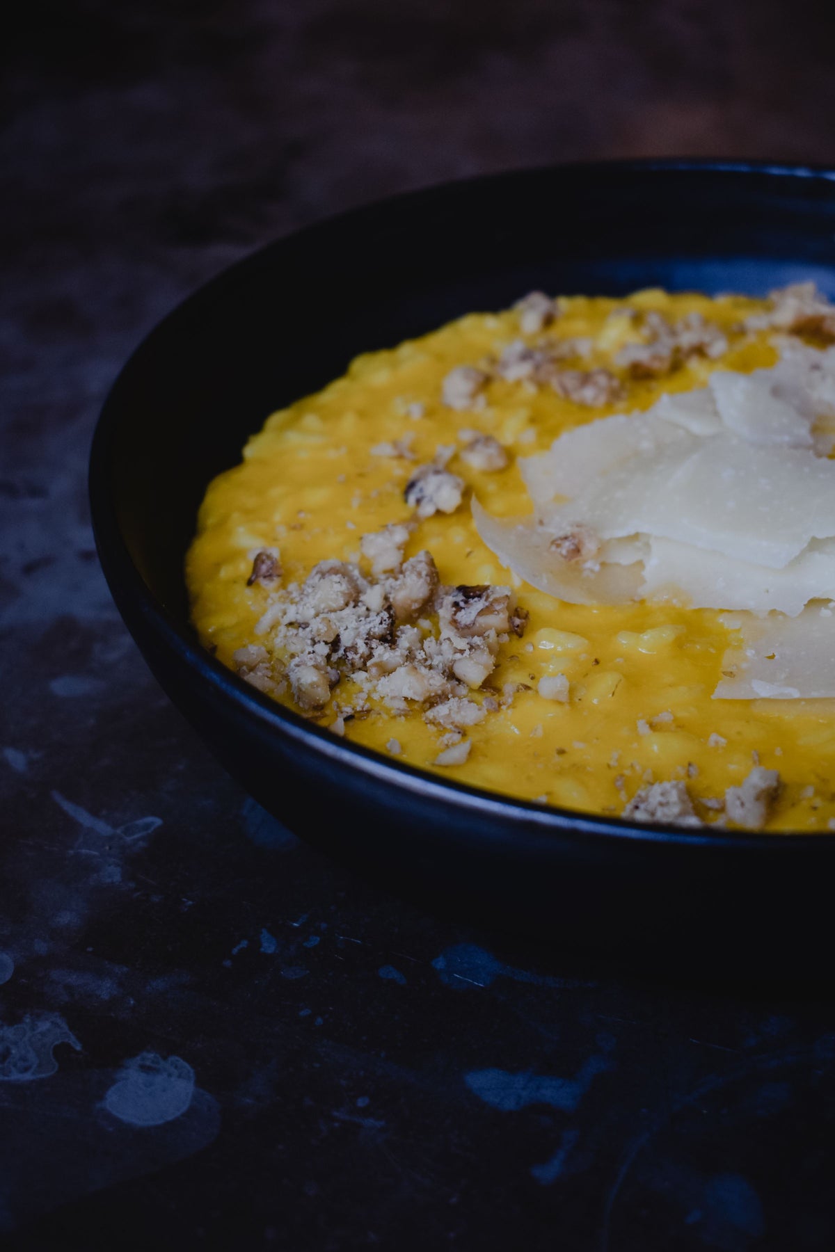 Risotto alla milanese with truffle, plated in Milan