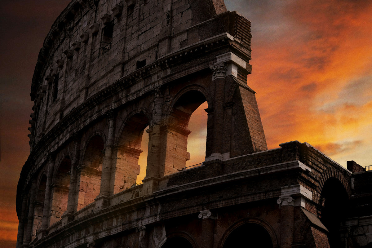 The Colosseum's arches against a fiery sunset sky
