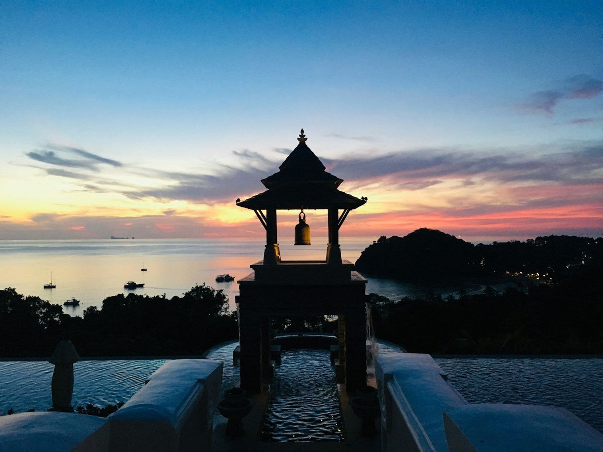A bell pavilion silhouetted at sunset above Ba Kan Tiang Beach, Koh Lanta