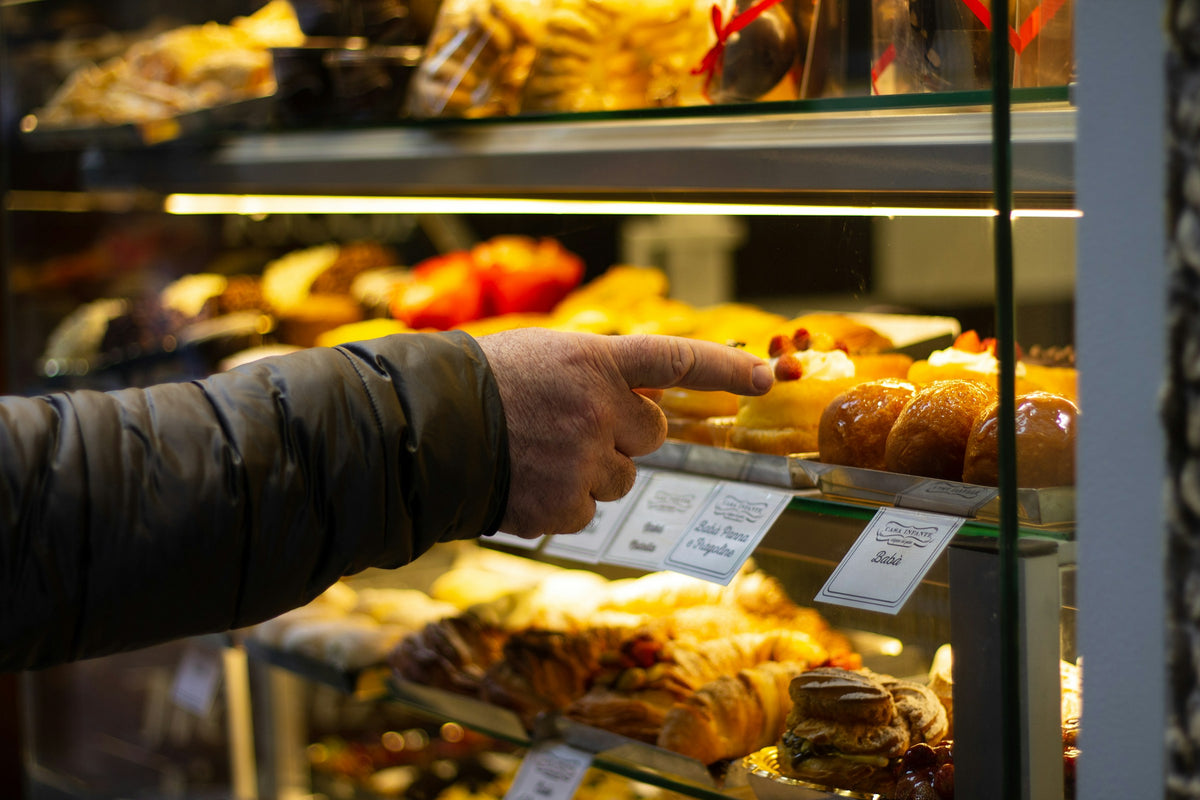 Choosing babà at a Naples pastry counter