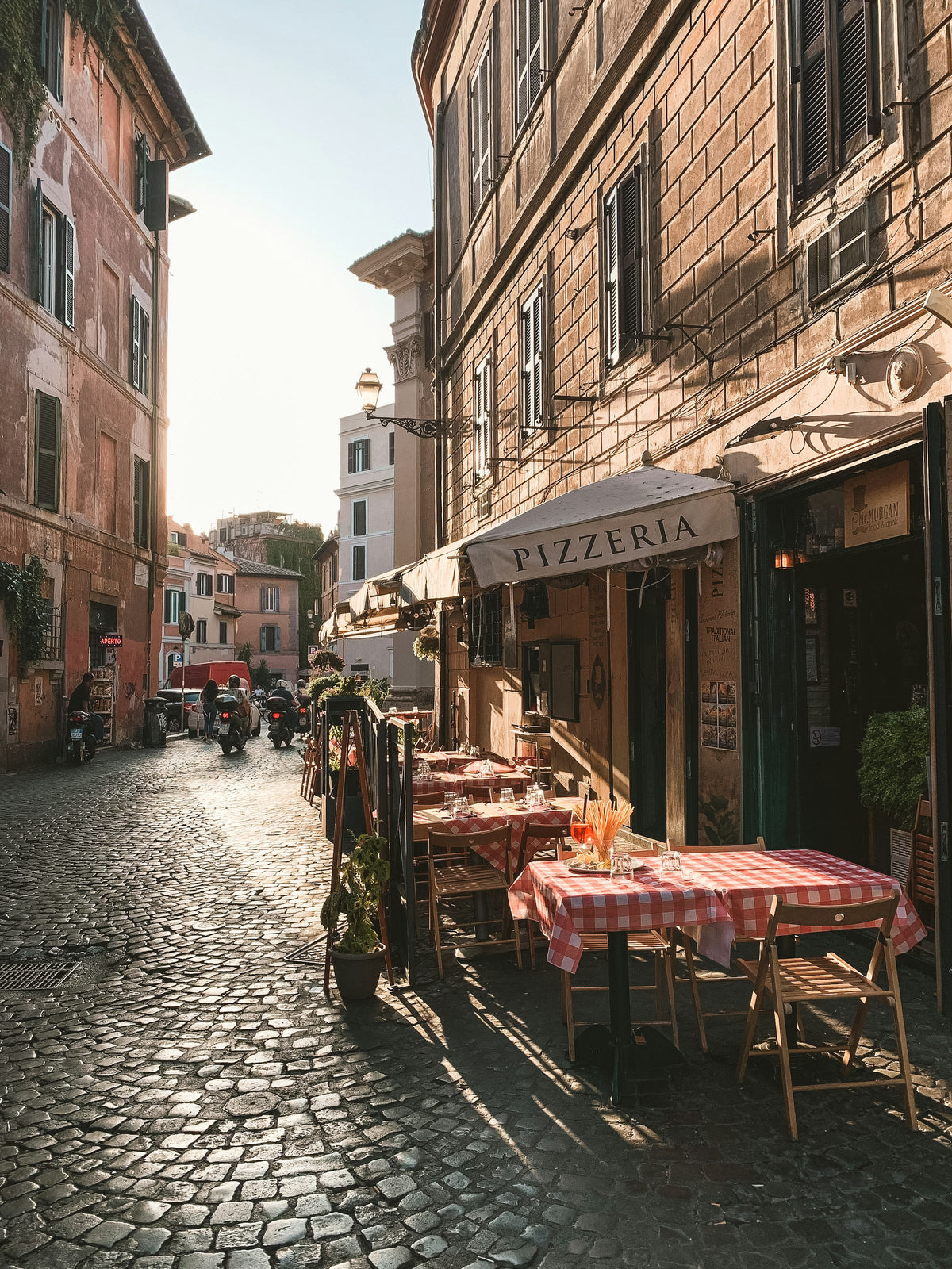 Checked tablecloths outside a pizzeria on a cobbled street in Trastevere
