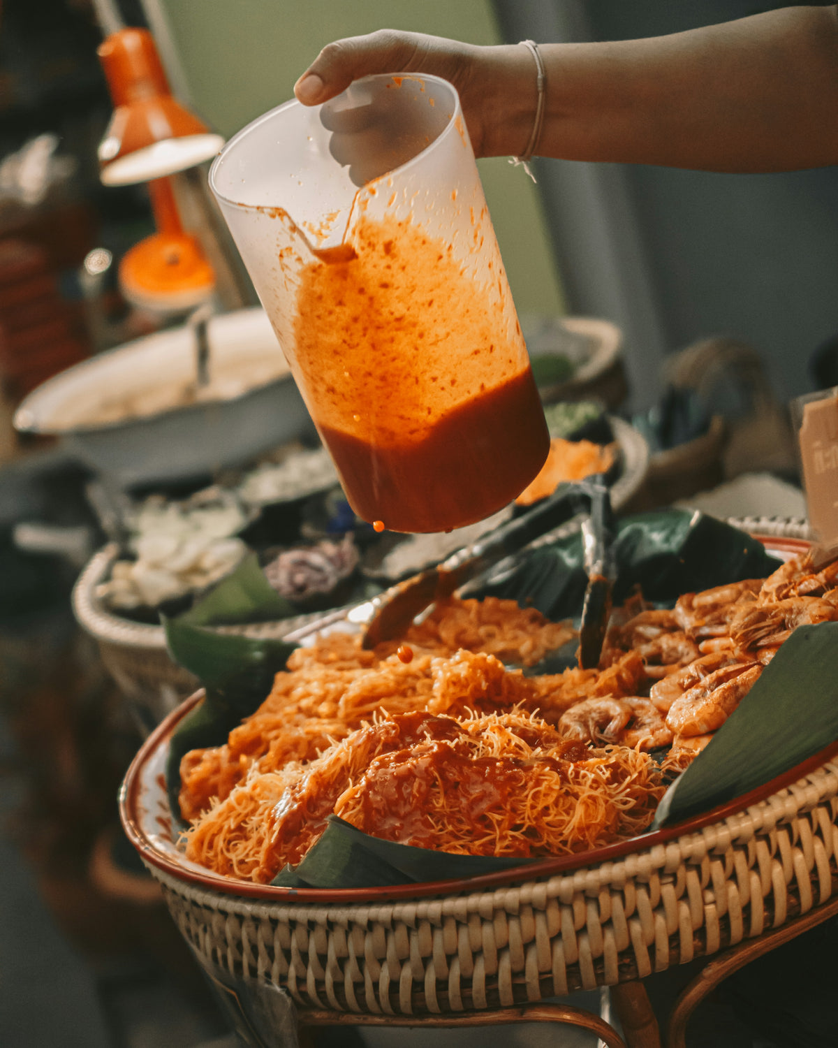 Sauce poured over crispy noodles at a market stall in Phuket