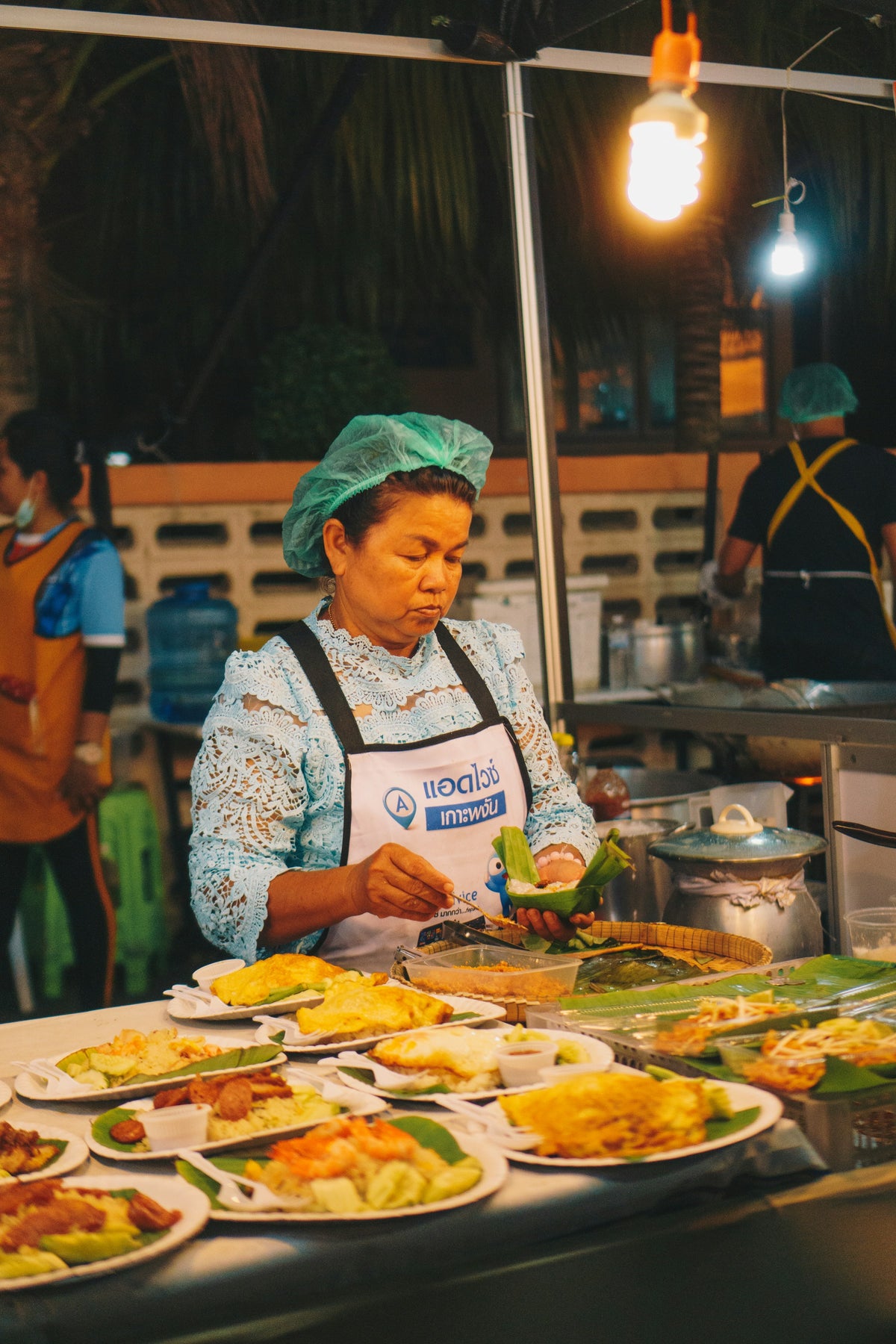 Street food vendor plating dishes at a night market in Phuket