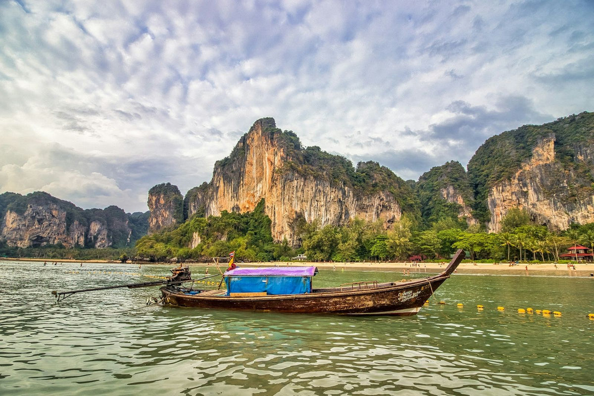 A longtail boat in front of the Railay cliffs