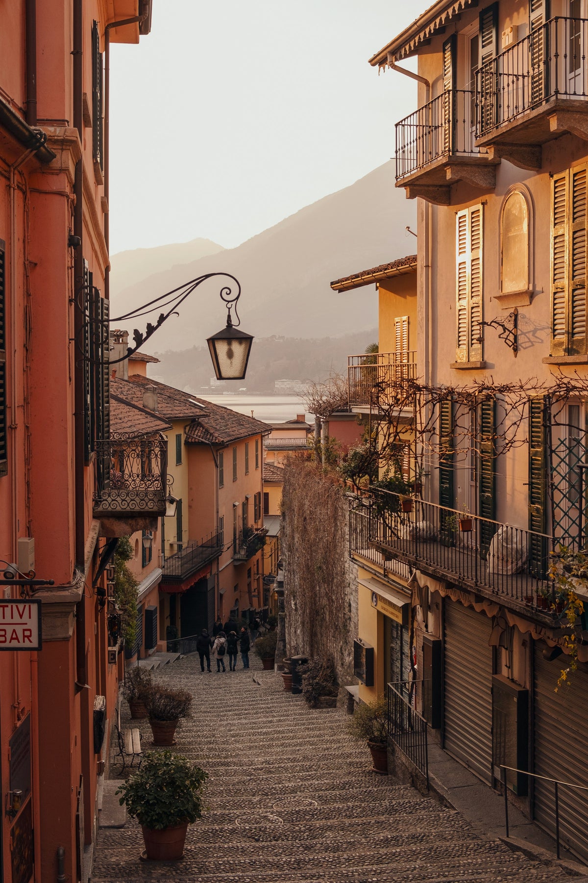 People walking a cobblestone street in Bellagio at golden hour