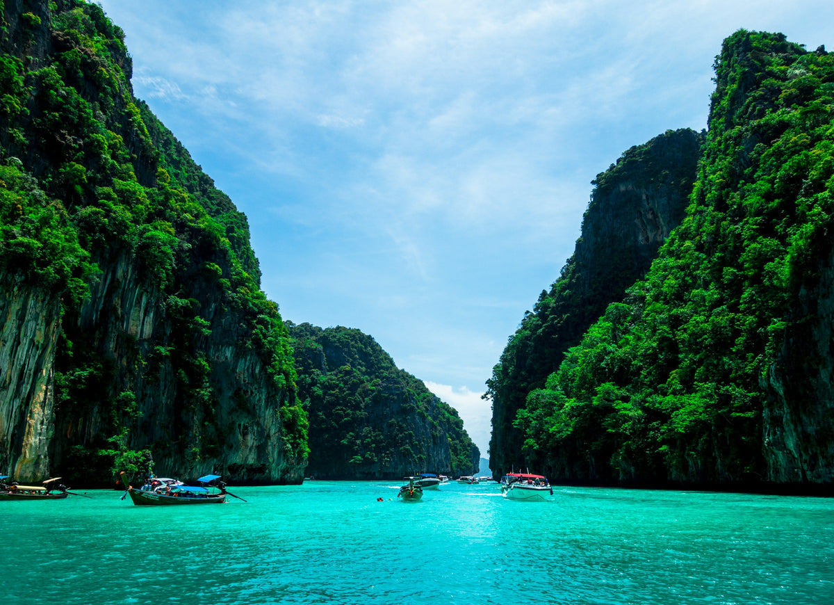 Longtail boats in Pileh cove between limestone cliffs, Phi Phi Islands
