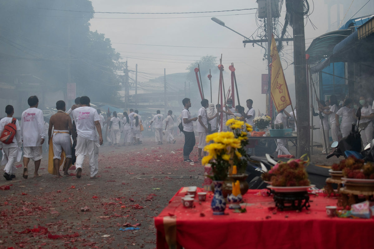 Offering table and devotees in white during the Phuket Vegetarian Festival