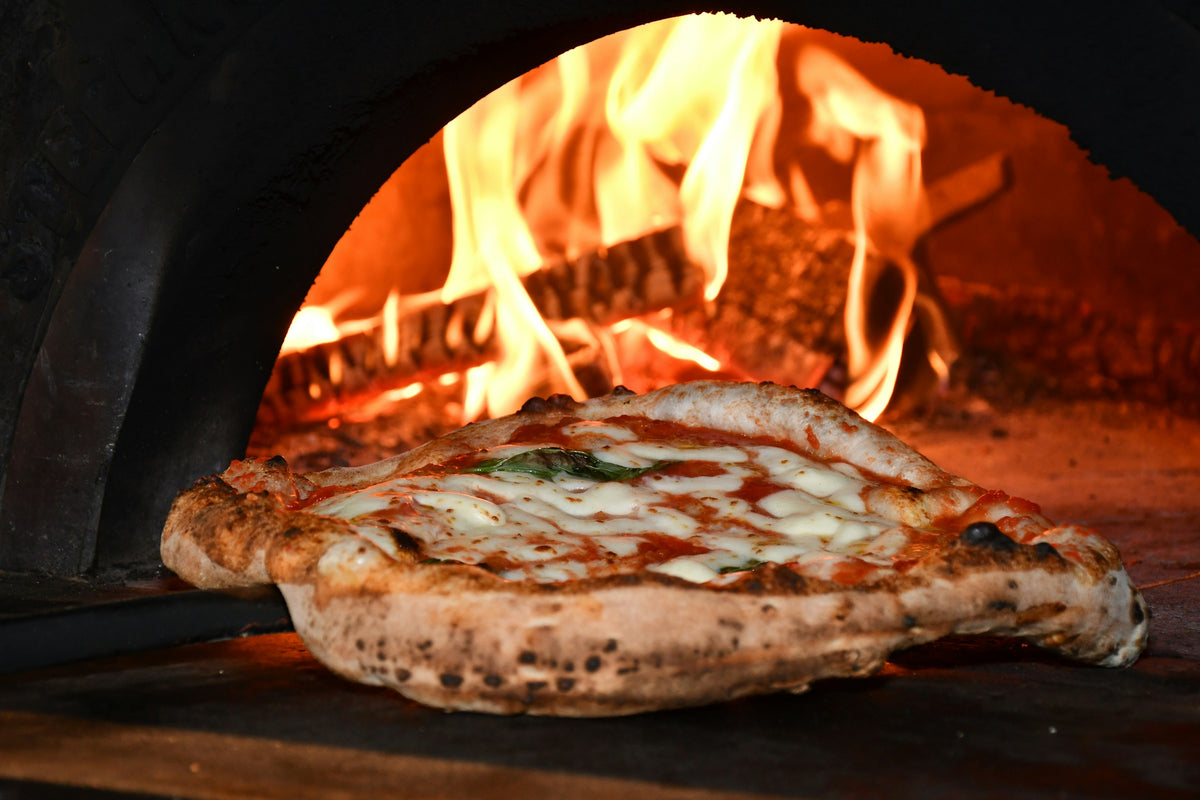 Neapolitan pizza baking in a wood-fired oven