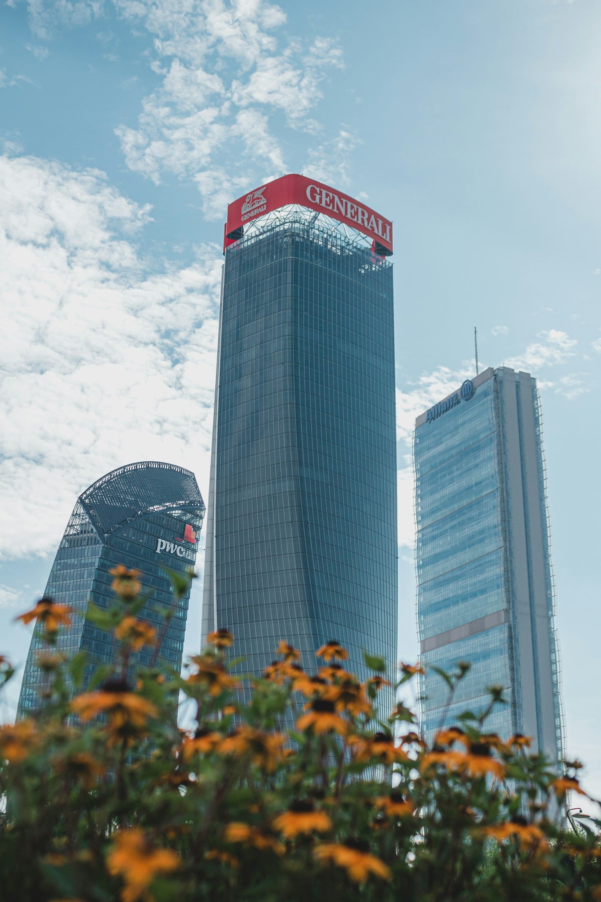 The CityLife towers behind orange flowers