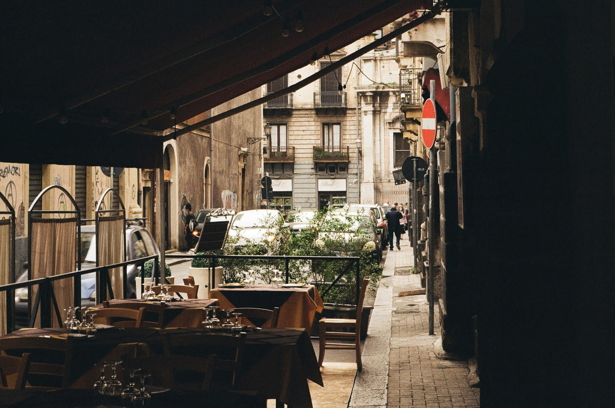 Laid tables under the awning of a trattoria