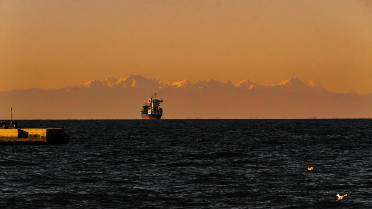 A ship in the gulf with the Alps beyond