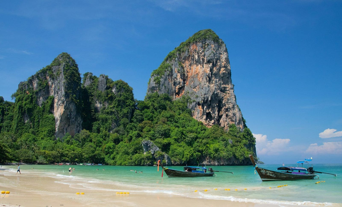 Longtail boats moored off Railay Beach below the limestone cliffs