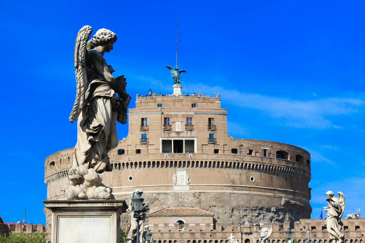 An angel statue on Ponte Sant'Angelo, with Castel Sant'Angelo behind