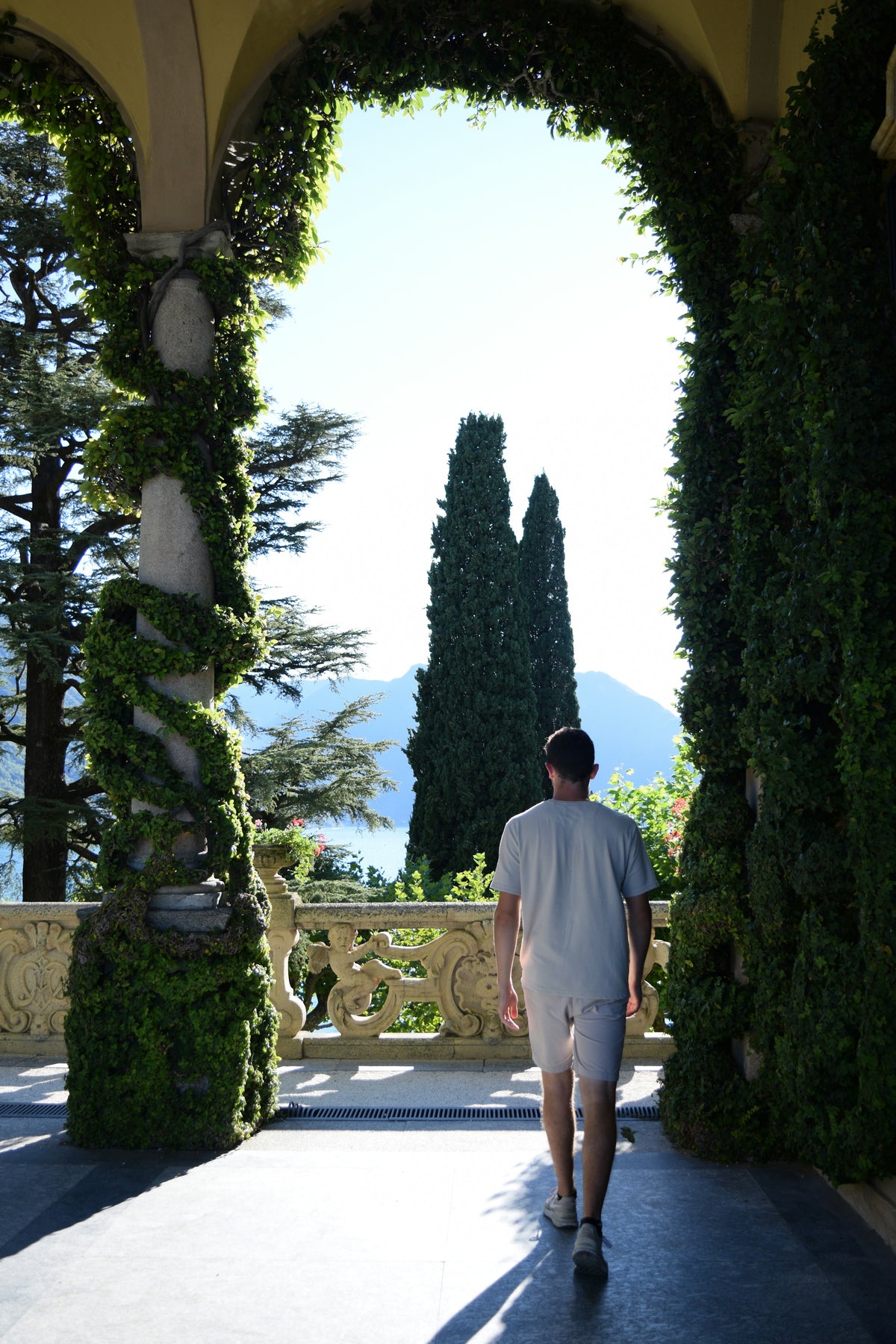A visitor walking through a gate at Villa del Balbianello