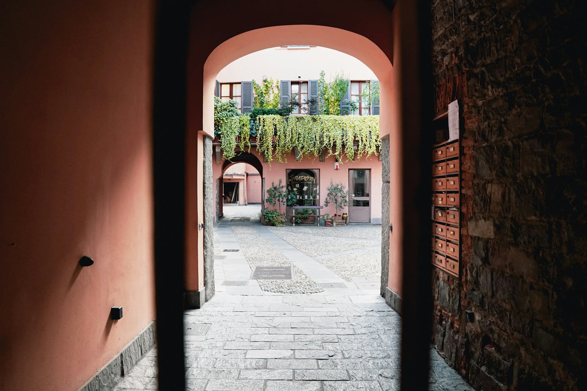 Through an archway into a green courtyard
