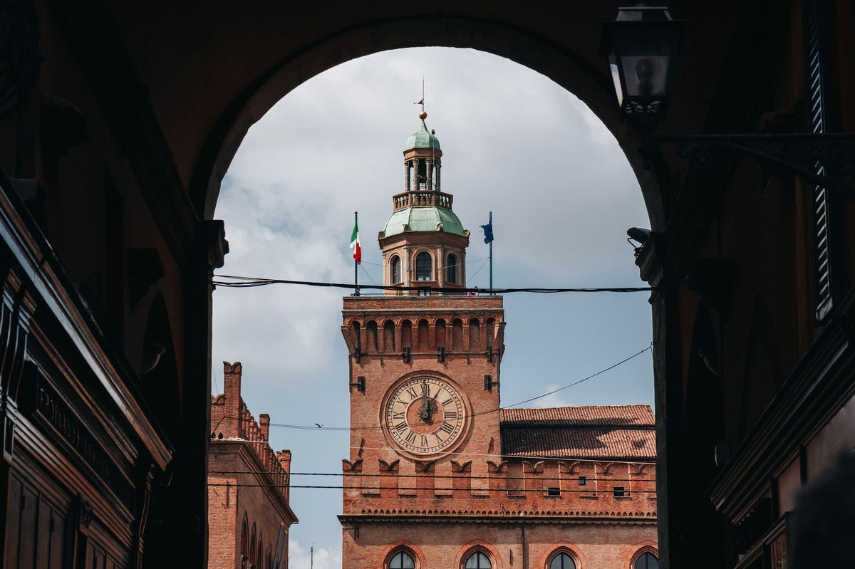 A framed view of the clock tower of Palazzo d'Accursio