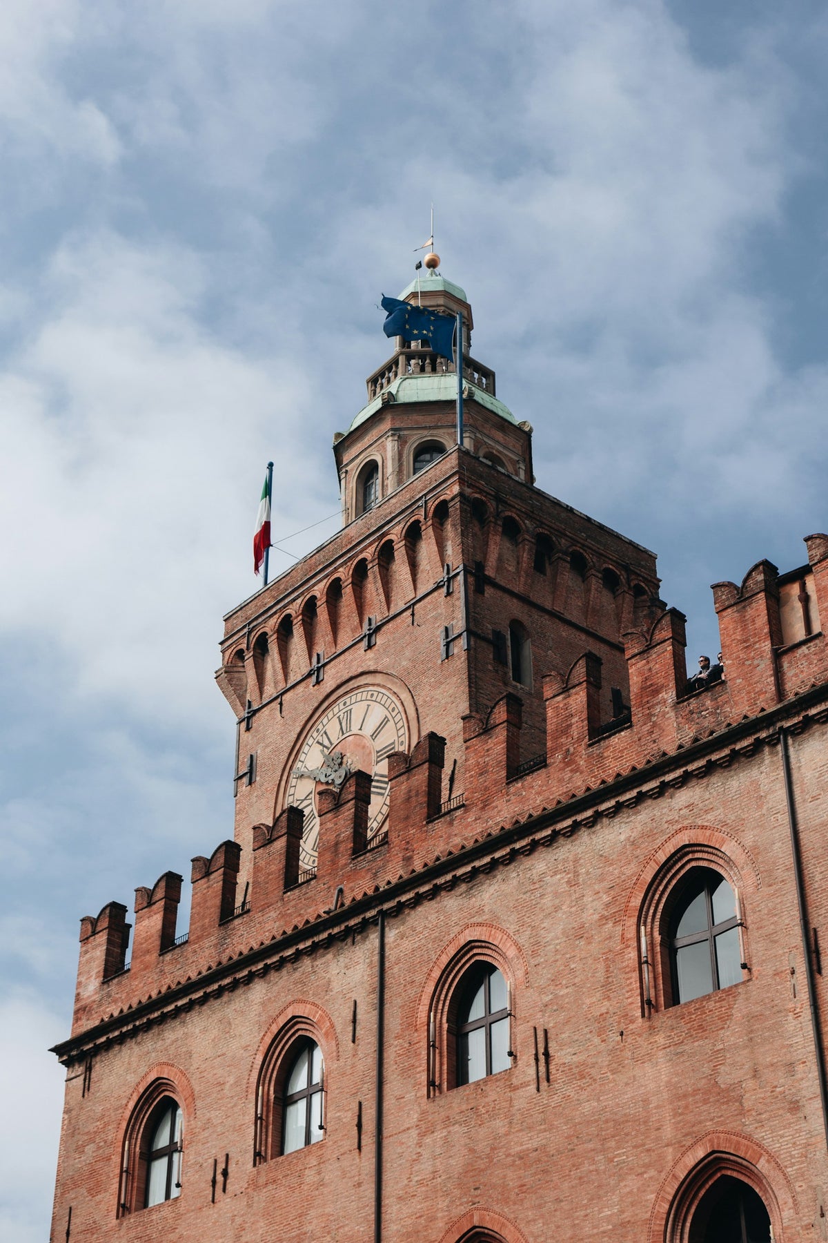 A tall brick clock tower in Bologna, 'la Dotta, la Grassa, la Rossa'