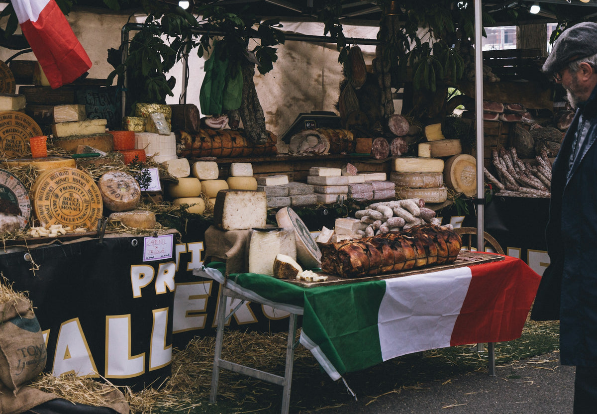 A shop counter stacked with cheeses in Bologna