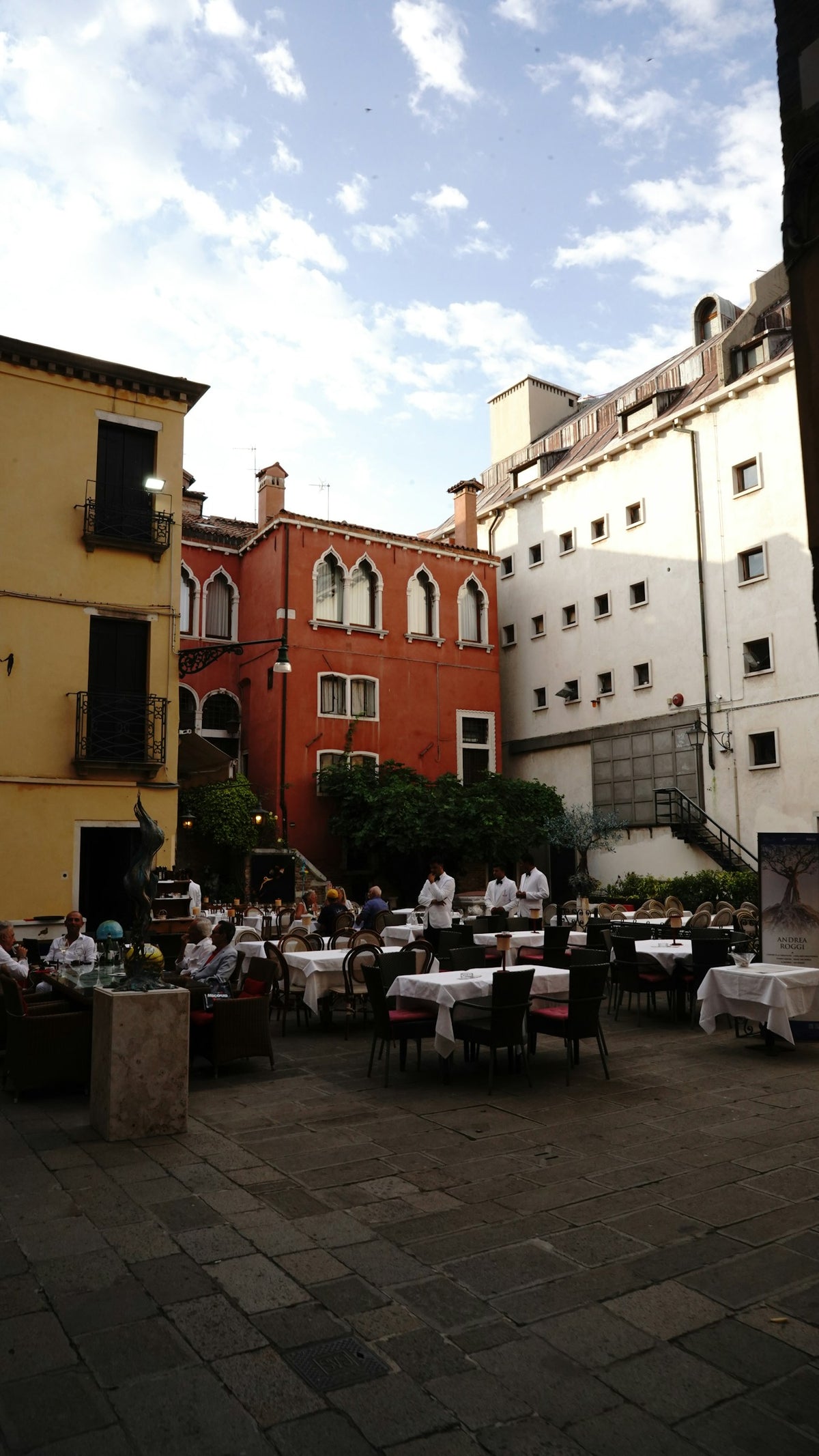 People sitting at tables in a courtyard in Bologna