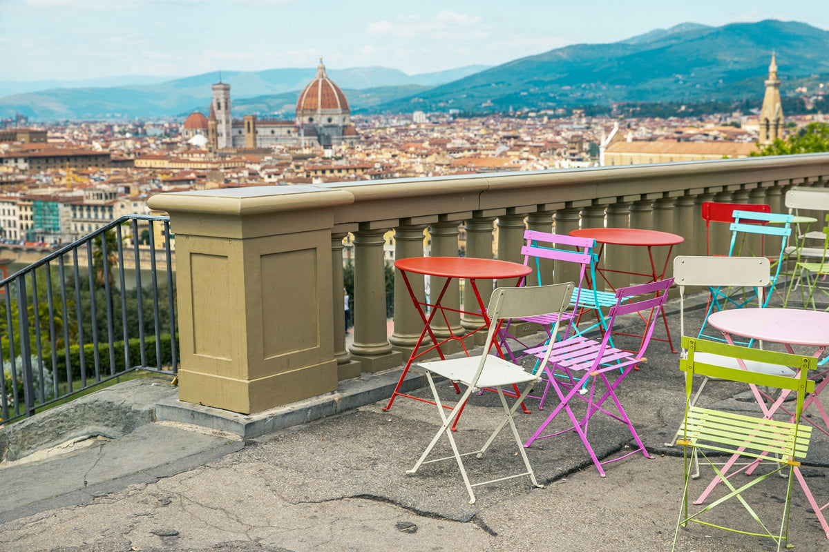 Colourful café chairs on a terrace above Florence and the Duomo