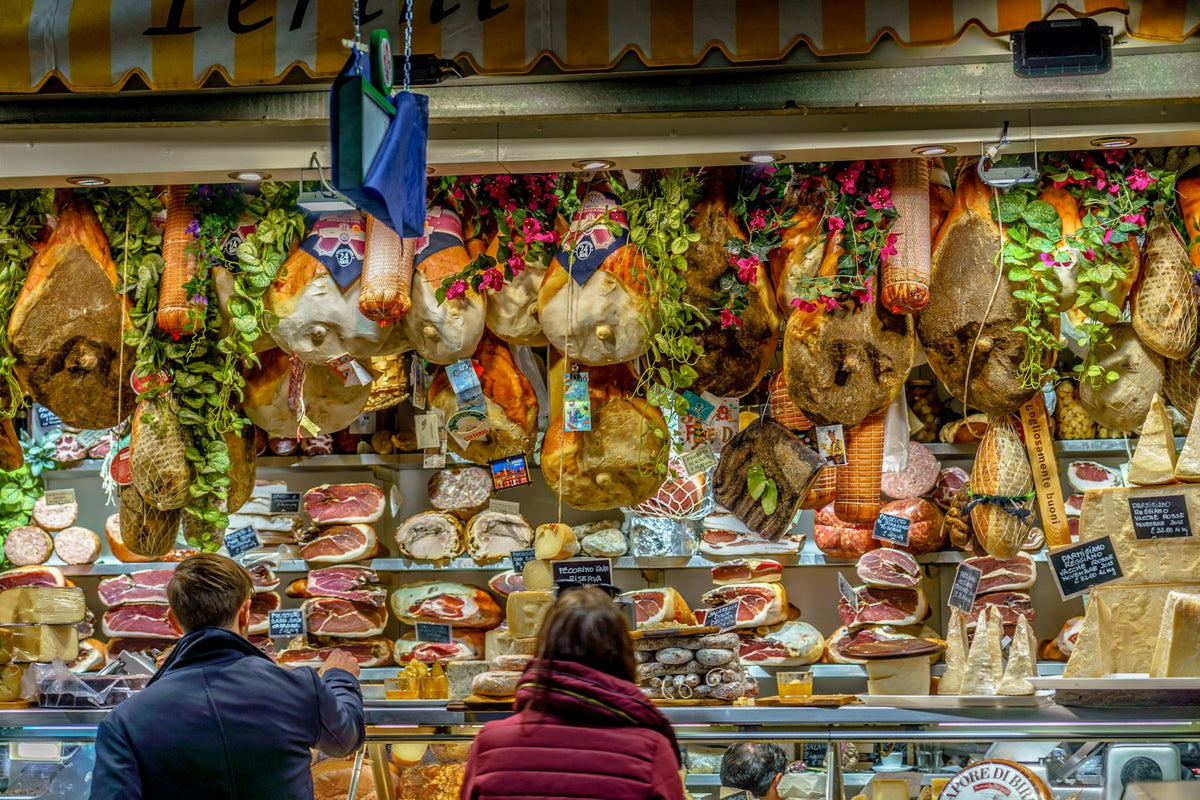 Hams, salami and cheeses on a counter at the Mercato Centrale
