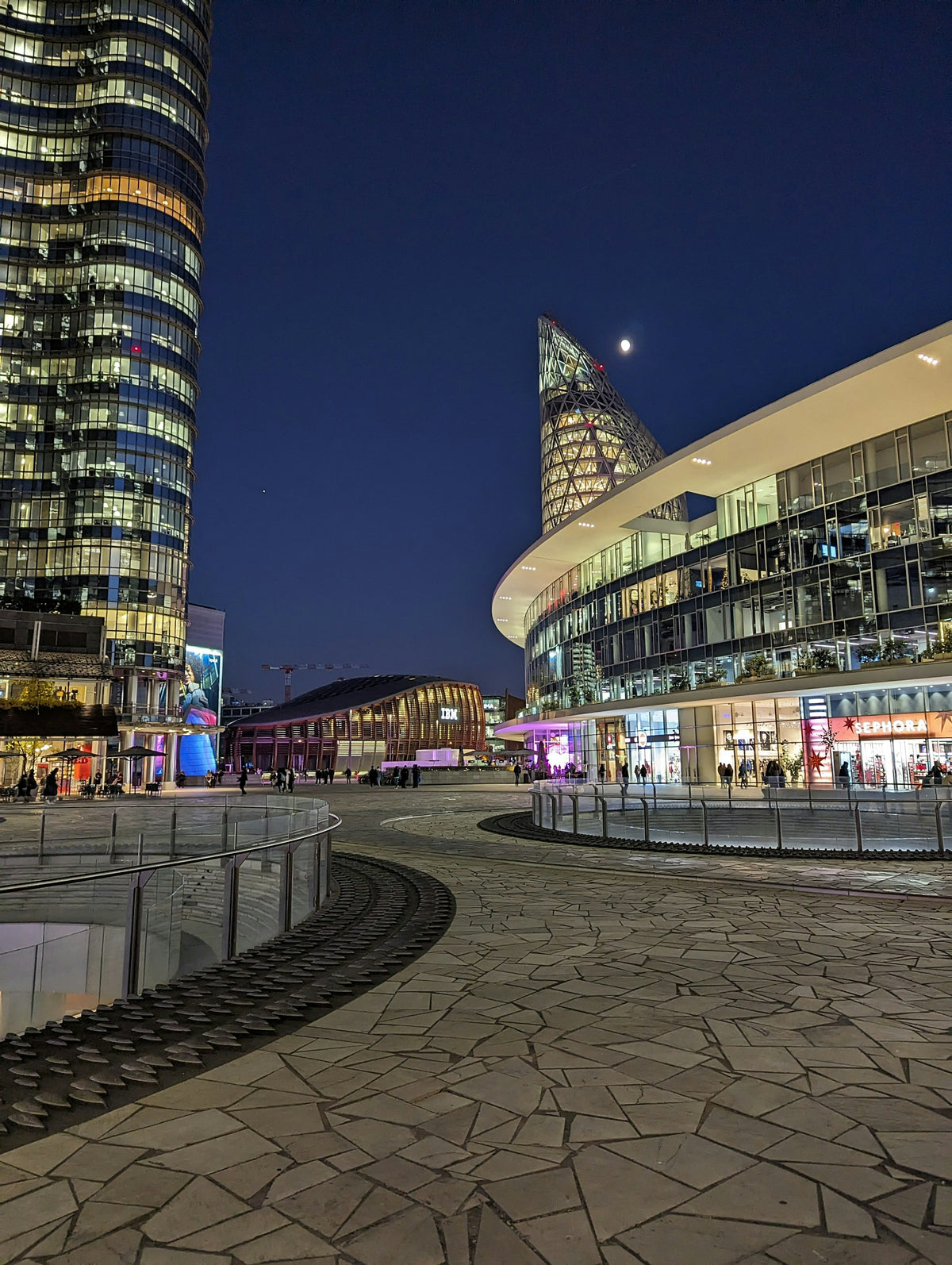A circular walkway near the UniCredit Tower at night